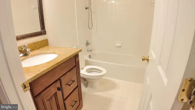 a bathroom with a granite countertop sink a toilet and shower