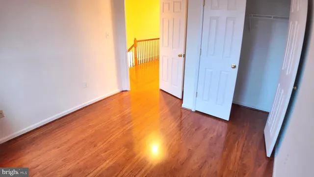 an empty room with wooden floor and entrance