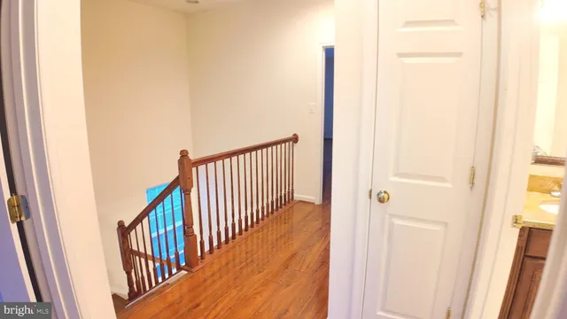 a view of a hallway with wooden floor and staircase