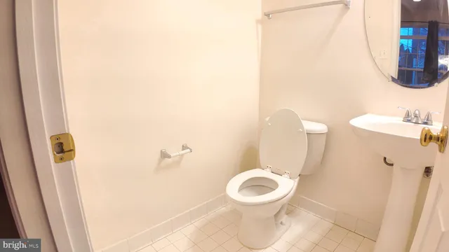 a white toilet sitting next to a white sink and vanity