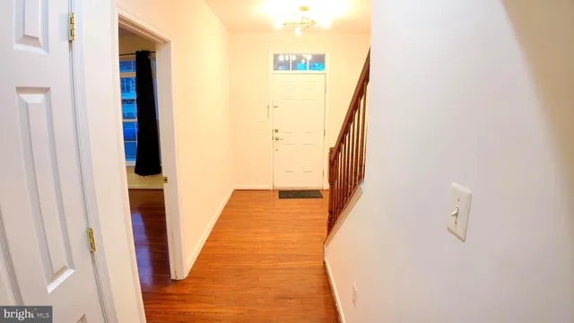 a view of a hallway with wooden floor and entryway