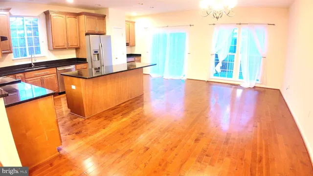 a view of a kitchen with kitchen island a sink wooden floor and a glass door