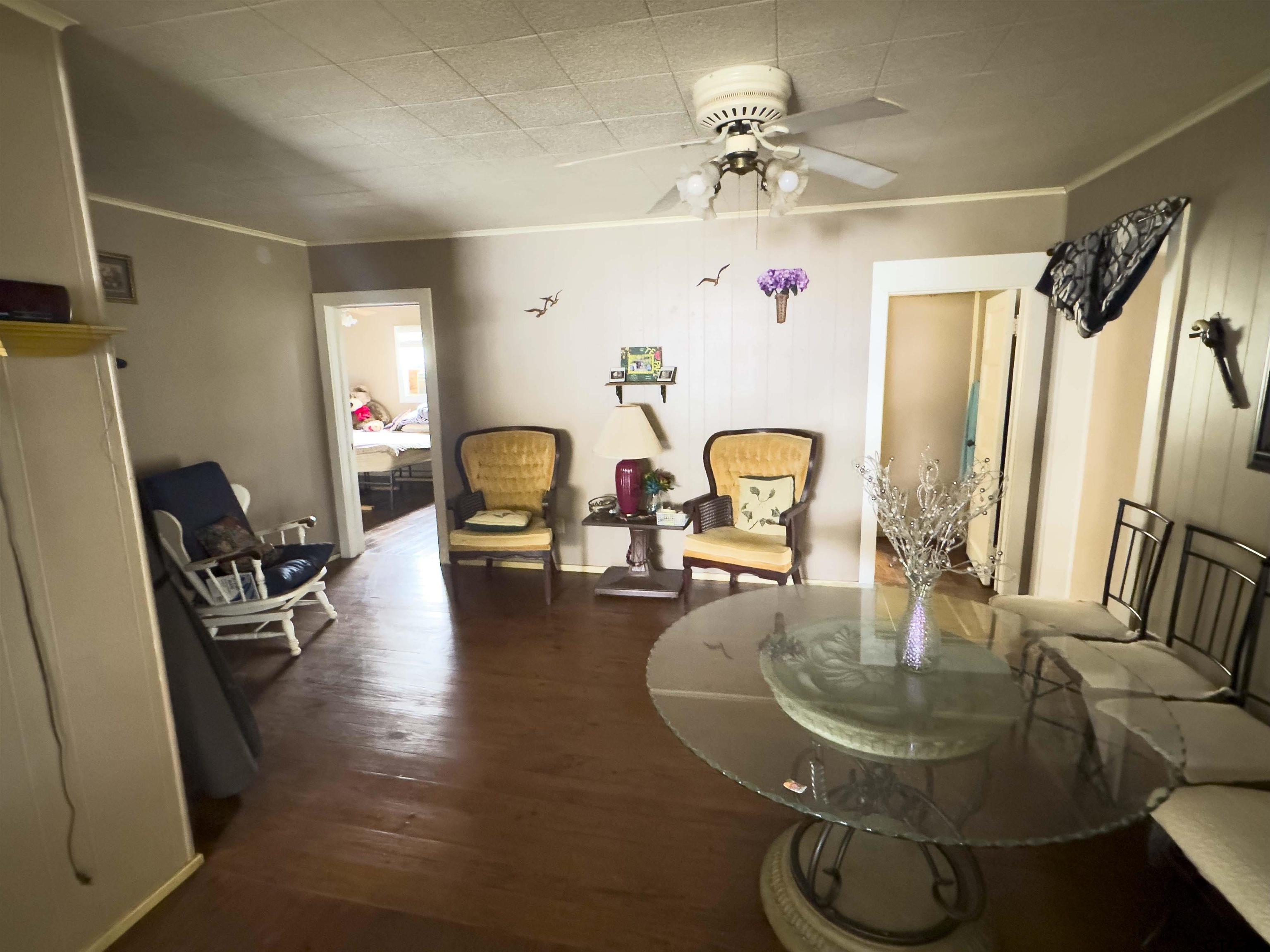 215 Cleveland Street Winfield, TX 75455 - Photo 5 of 17 a dining room with wooden floor and a chandelier