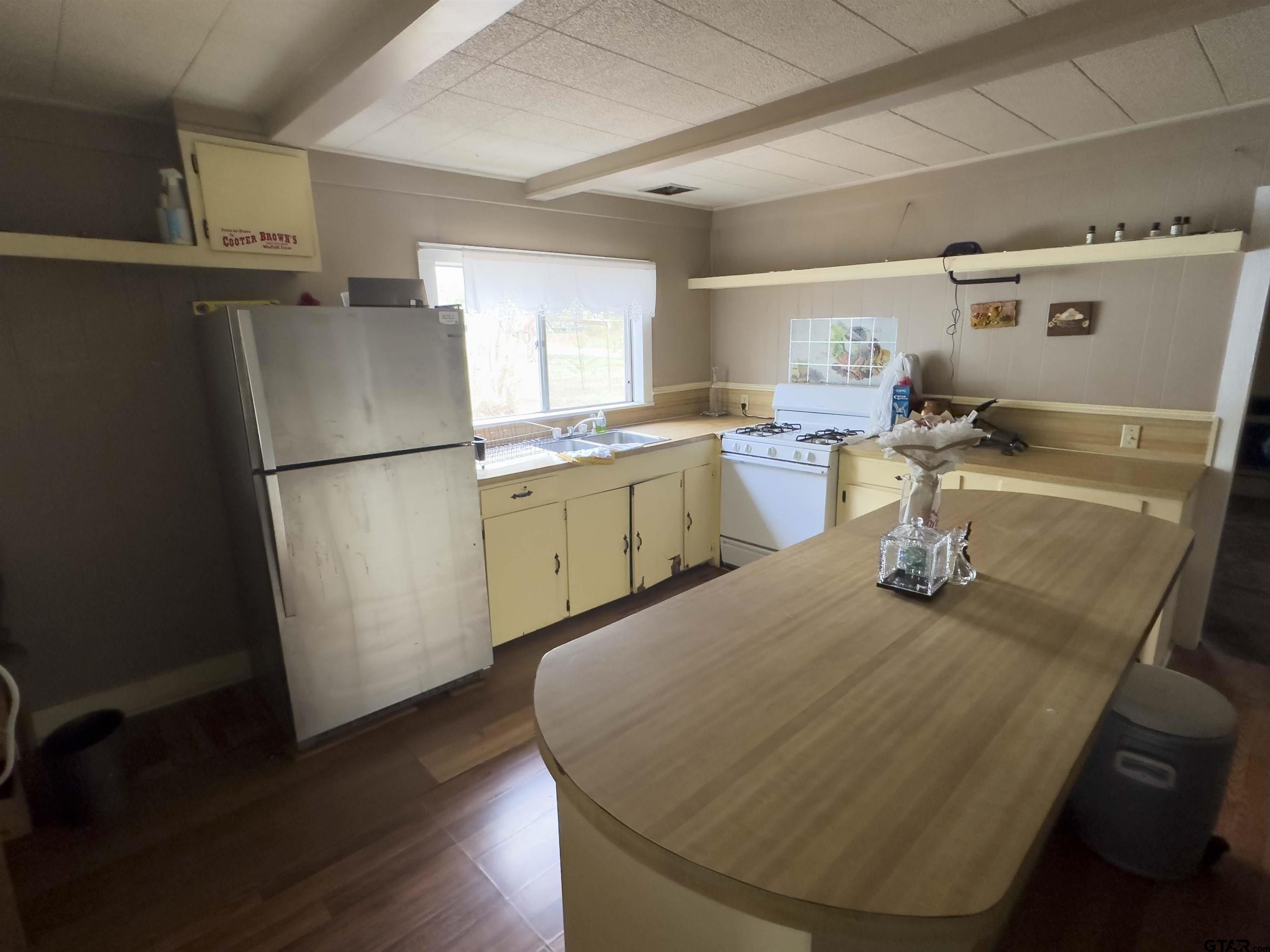 215 Cleveland Street Winfield, TX 75455 - Photo 6 of 17 a kitchen with a sink appliances and wooden floor
