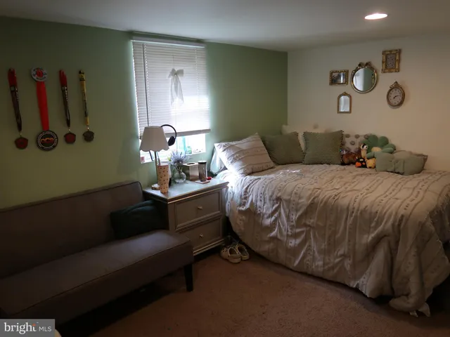 a bedroom with a bed and a painting on the wall