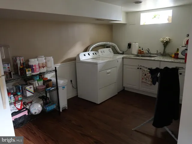 a utility room with wooden floor washer and dryer