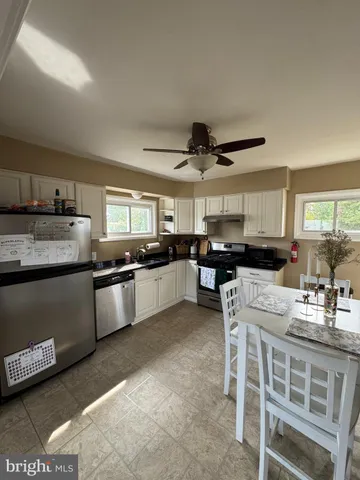 a kitchen with stainless steel appliances kitchen island granite countertop a sink and cabinets