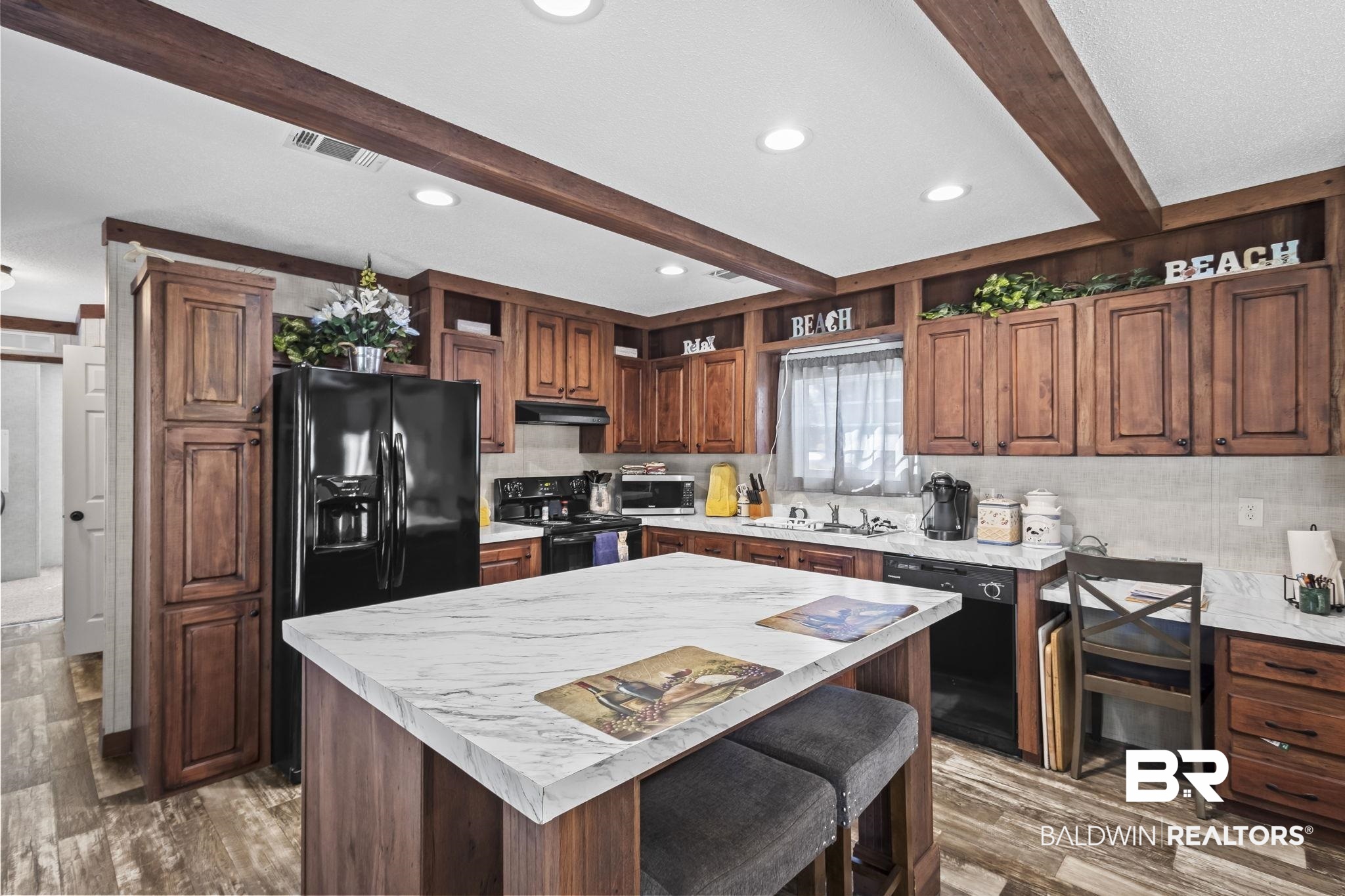 12960 7th Street Lillian, AL 36549 - Photo 25 of 25 Kitchen with light countertops, open shelves, under cabinet range hood, visible vents, and black appliances