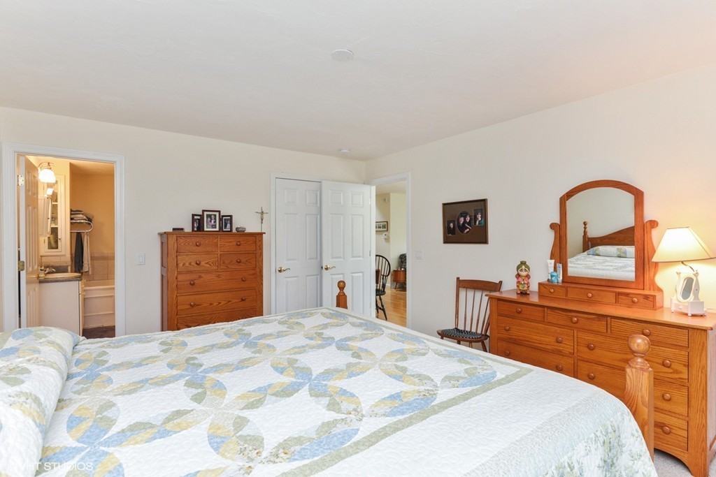 23 Gold Leaf Lane, Unit 23 Mashpee, MA 02649 - Photo 11 of 15 a bedroom with a bed and a dresser in it