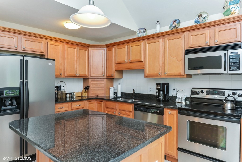 23 Gold Leaf Lane, Unit 23 Mashpee, MA 02649 - Photo 6 of 15 a kitchen with stainless steel appliances granite countertop a sink a stove counter space and cabinets