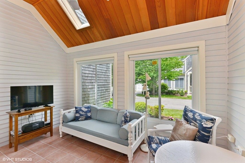 23 Gold Leaf Lane, Unit 23 Mashpee, MA 02649 - Photo 8 of 15 a living room with furniture a flat screen tv and a floor to ceiling window