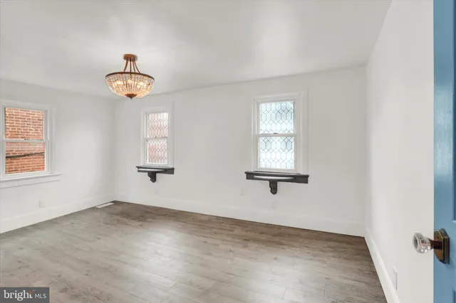 an empty room with a wooden floor and a window