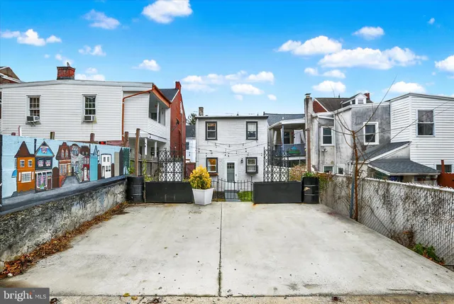 a view of a house with a yard and wooden fence