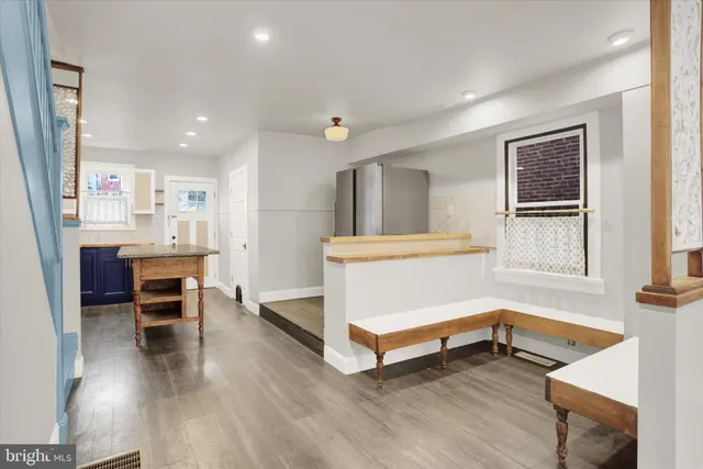 a view of a refrigerator in kitchen and white cabinets