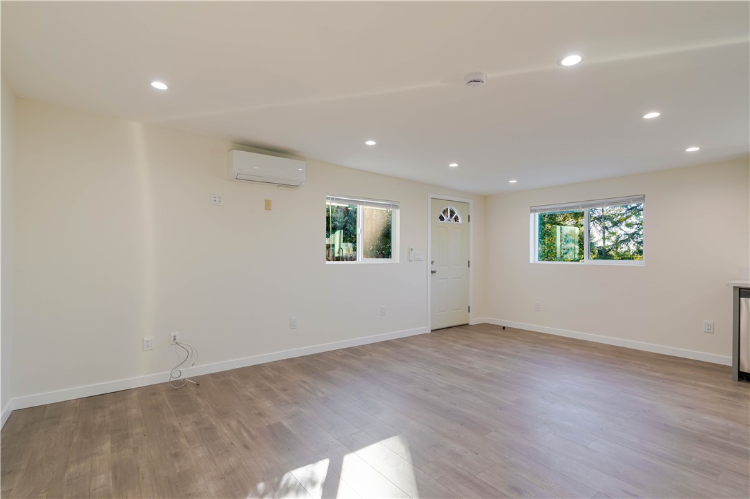 10528 1/4 Hillhaven Avenue Tujunga, CA 91042 - Photo 3 of 13 an empty room with a wooden floor and windows