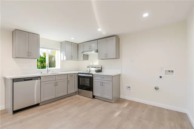a kitchen with granite countertop a sink stainless steel appliances and cabinets