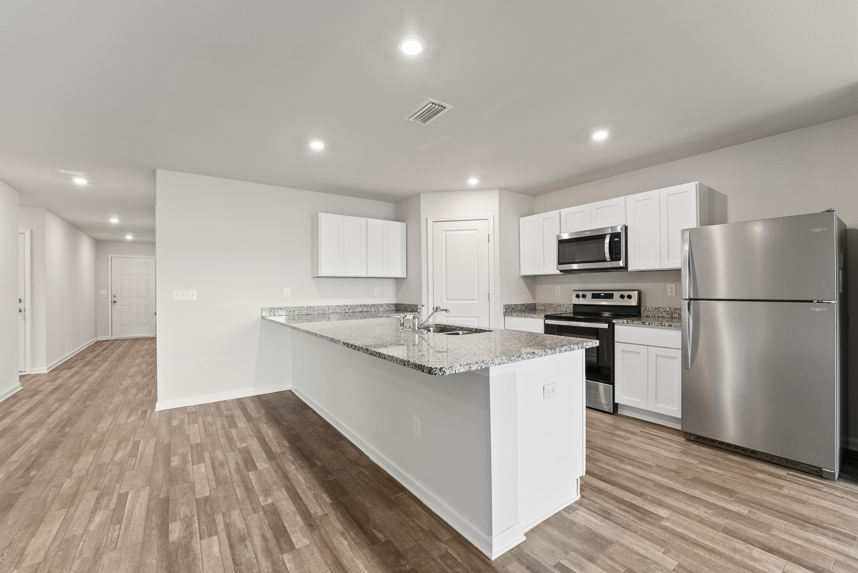 76 Cora Road DeFuniak Springs, FL 32433 - Photo 7 of 27 a kitchen with a refrigerator a stove top oven and wooden floor