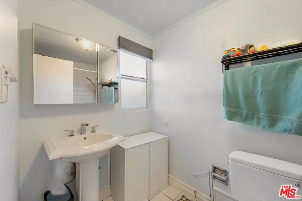 a bathroom with a sink a toilet and mirror