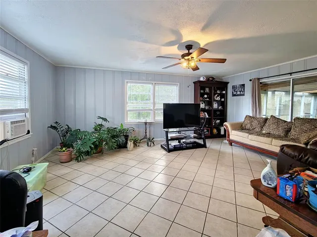 a living room with furniture a flat screen tv and a window