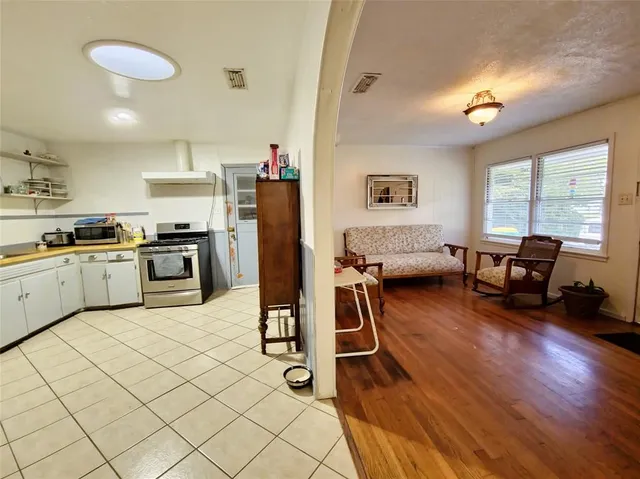 a kitchen with furniture a refrigerator and a stove top oven