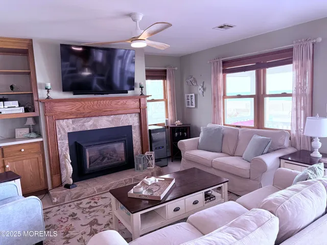 a living room with furniture a flat screen tv and a fireplace