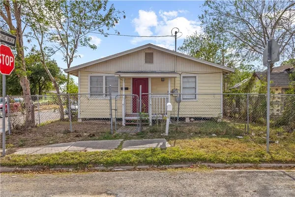 a front view of house with small garden and tree