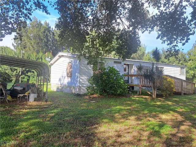 a view of a house with a yard and sitting area