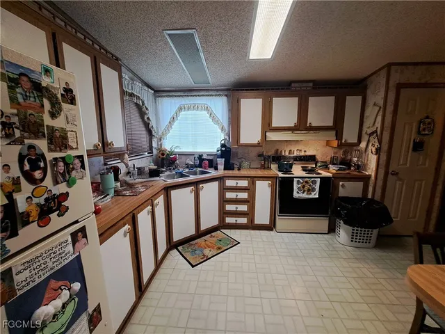 a view of a dining room with furniture and a kitchen view