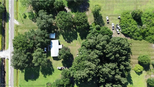 an aerial view of residential house with outdoor space and trees all around
