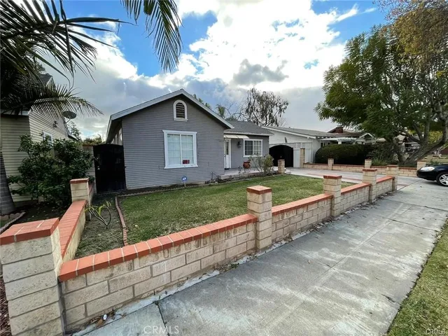 a view of a house with a yard and large tree