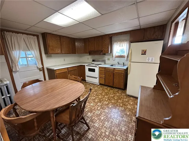 a kitchen with a stove a refrigerator and a dining table