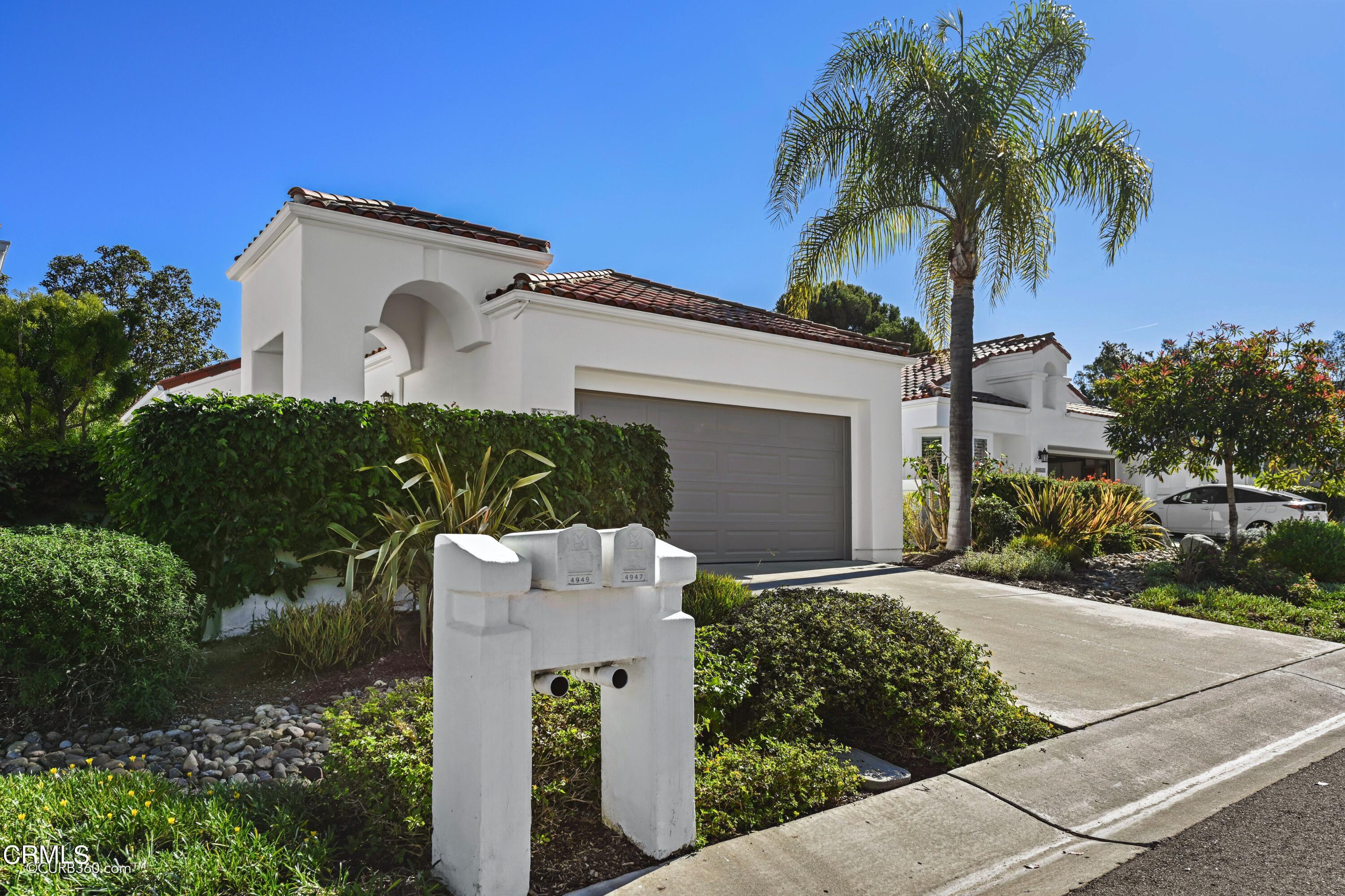 front view of a house with a yard and potted plants