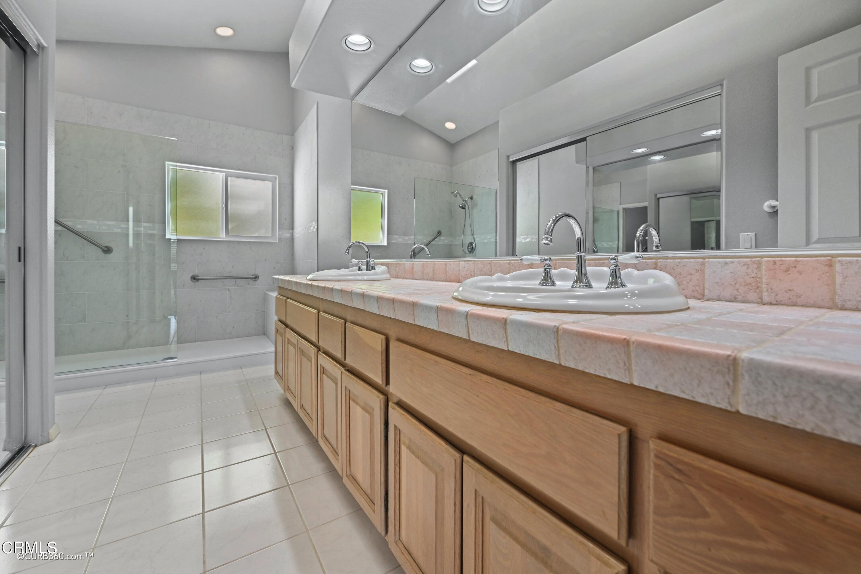 4947 Tilos Way Oceanside, CA 92056 - Photo 17 of 37 a spacious bathroom with a granite countertop sink a mirror and a bathtub