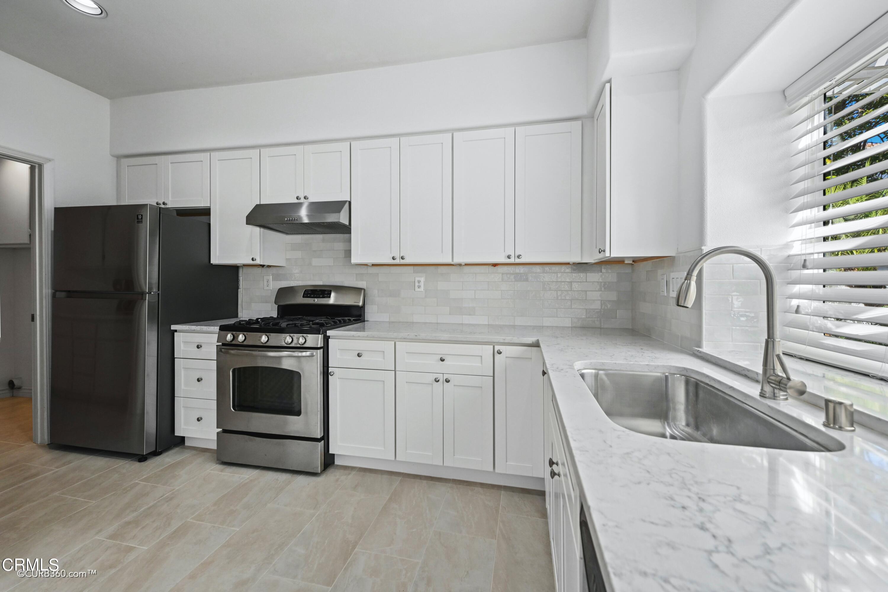 4947 Tilos Way Oceanside, CA 92056 - Photo 7 of 37 a kitchen with a sink a refrigerator and cabinets