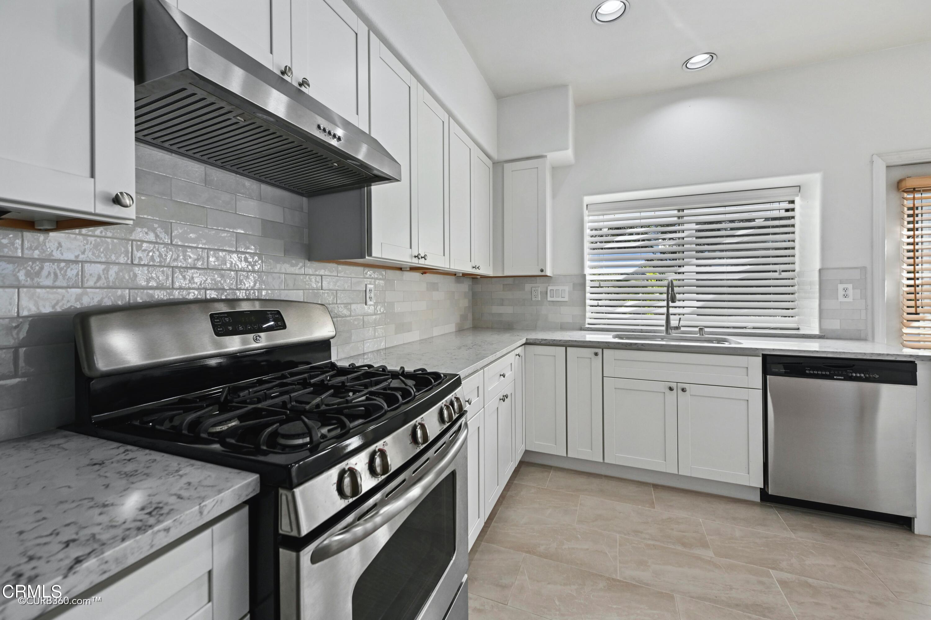 4947 Tilos Way Oceanside, CA 92056 - Photo 8 of 37 a kitchen with granite countertop a stove sink and cabinets