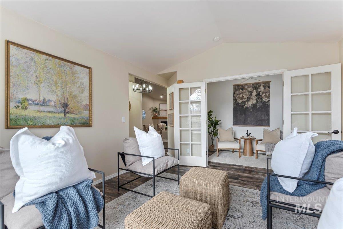1528 East Peridot Street Meridian, ID 83646 - Photo 12 of 28 Living room featuring lofted ceiling, wood finished floors, a fireplace, and a chandelier