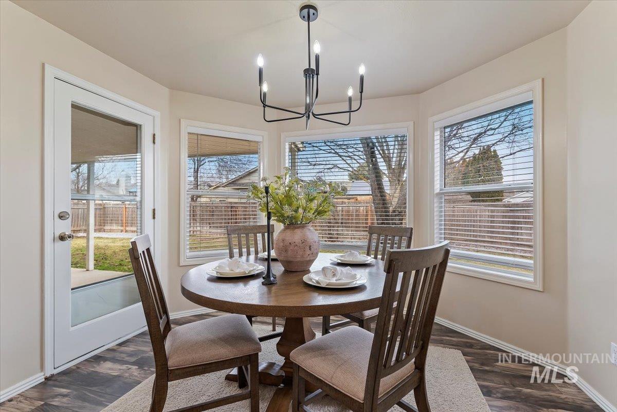 1528 East Peridot Street Meridian, ID 83646 - Photo 13 of 28 Dining room with dark wood-style floors and a chandelier