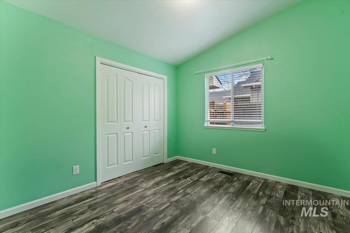 1528 East Peridot Street Meridian, ID 83646 - Photo 20 of 28 Unfurnished bedroom with vaulted ceiling, dark wood-style flooring, and a closet
