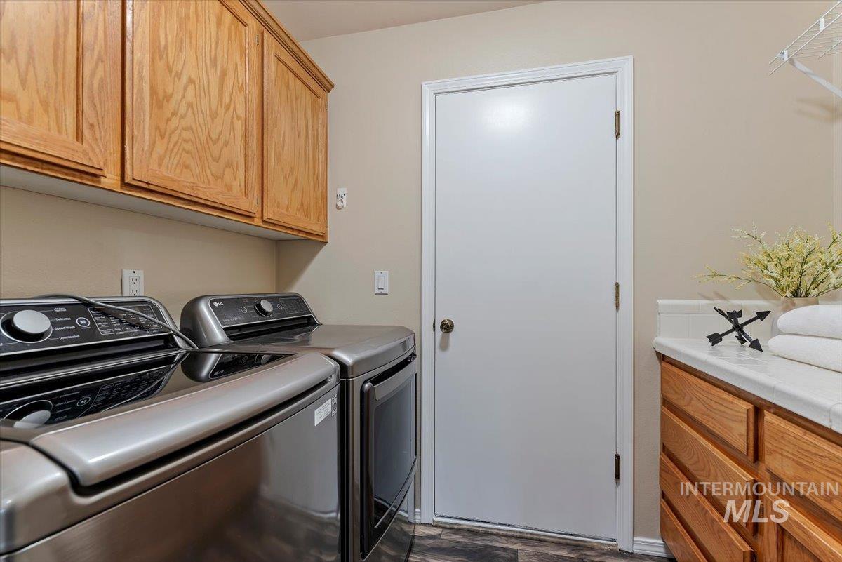 1528 East Peridot Street Meridian, ID 83646 - Photo 25 of 28 Laundry area featuring cabinet space, washer and dryer, and dark wood-type flooring
