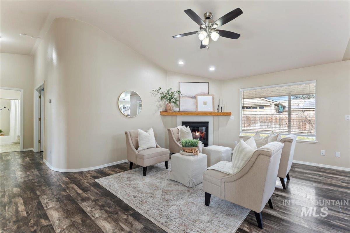 1528 East Peridot Street Meridian, ID 83646 - Photo 7 of 28 Living area featuring dark wood-type flooring, a glass covered fireplace, lofted ceiling, ceiling fan, and recessed lighting