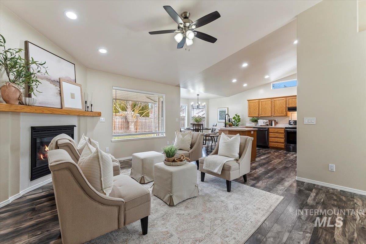 1528 East Peridot Street Meridian, ID 83646 - Photo 8 of 28 Living area featuring recessed lighting, a glass covered fireplace, dark wood-style floors, lofted ceiling, and ceiling fan
