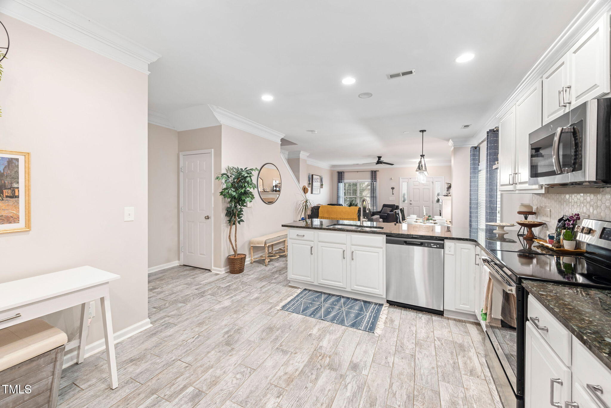 992 Ambergate Apex, NC 27502 - Photo 10 of 39 a kitchen with stainless steel appliances a stove a sink a refrigerator cabinets and wooden floor