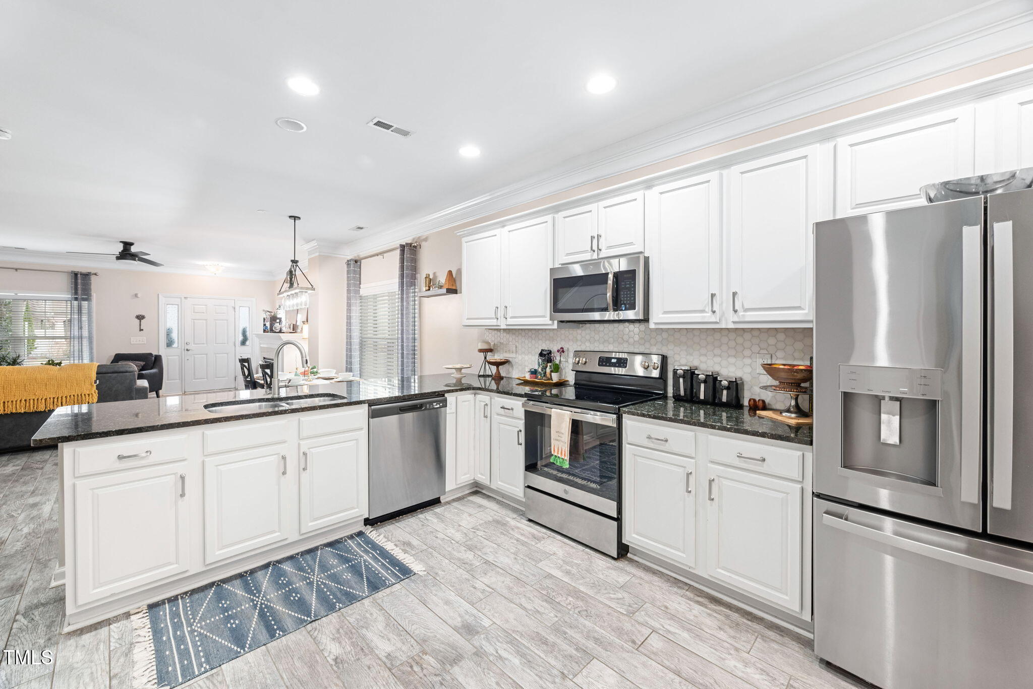 992 Ambergate Apex, NC 27502 - Photo 12 of 39 a kitchen with granite countertop white cabinets and stainless steel appliances