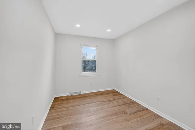 a view of a room with wooden floor and white walls