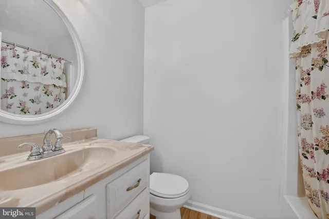 a bathroom with a granite countertop sink and a toilet