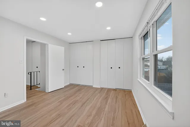 a view of wooden floor in an empty room with a window