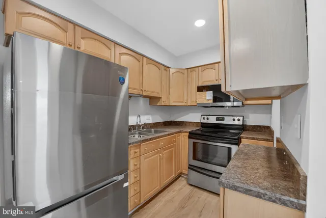 a kitchen with stainless steel appliances a refrigerator sink and stove