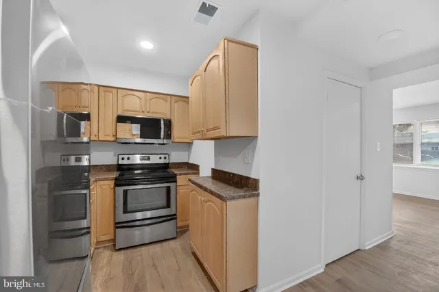 a kitchen with stainless steel appliances a stove microwave and sink