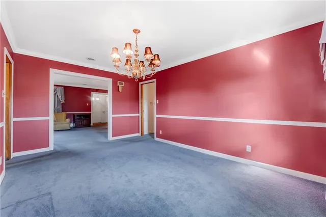 an empty room with closet and a chandelier fan