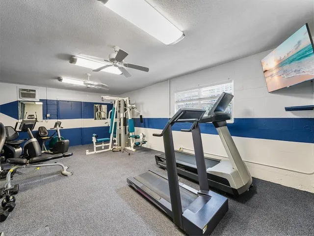 a room with gym equipment and a view of living room
